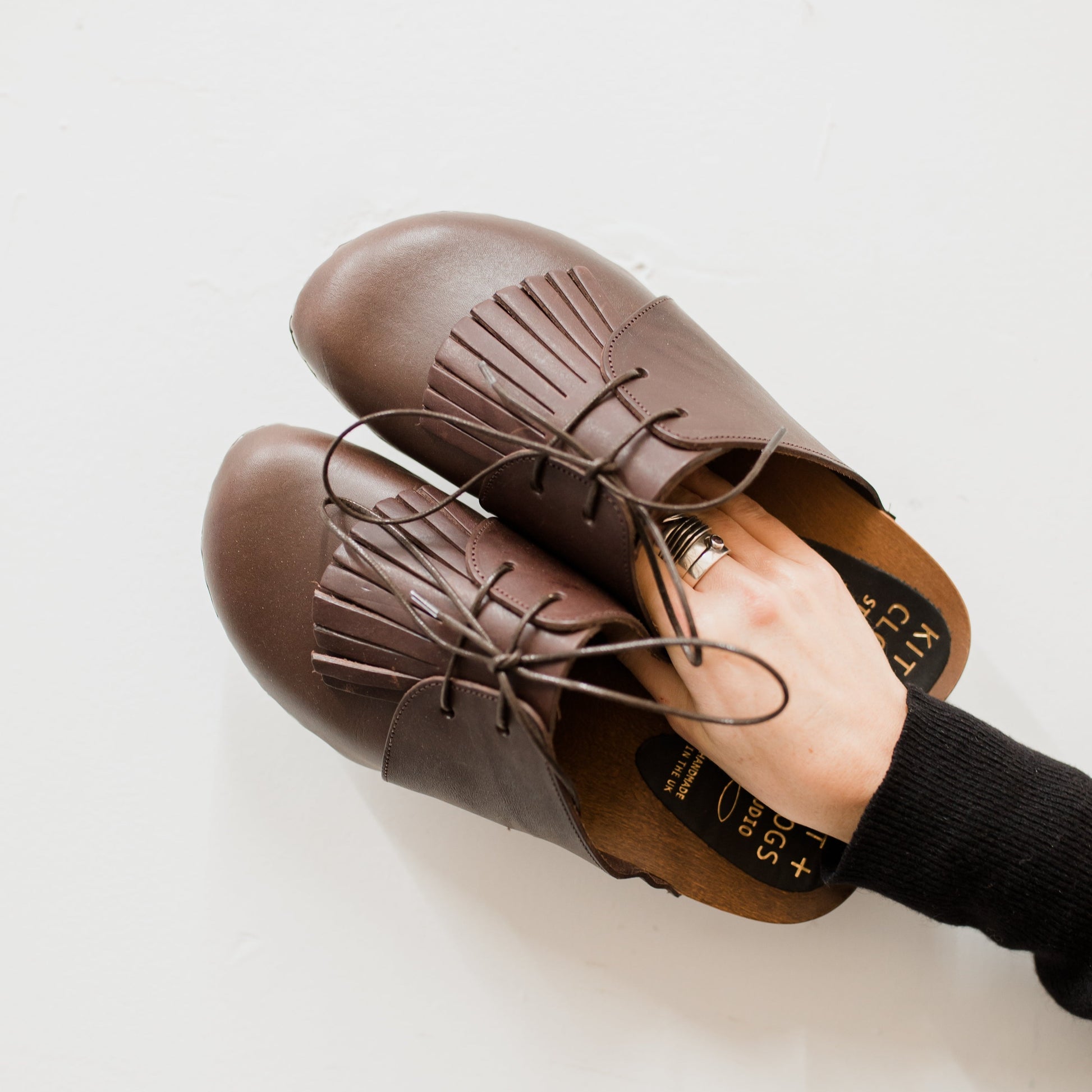 brown leather lace up clog mules with removable fringe tongue and flexible wooden base