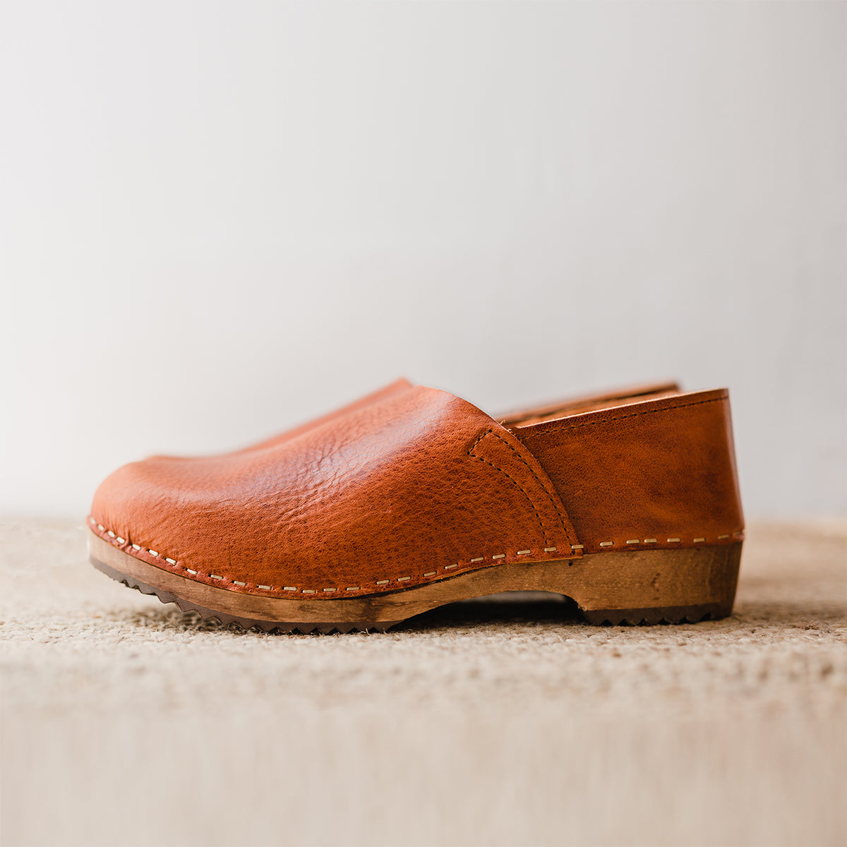 Cumin tan swedish clogs with a low wooden base and covered back